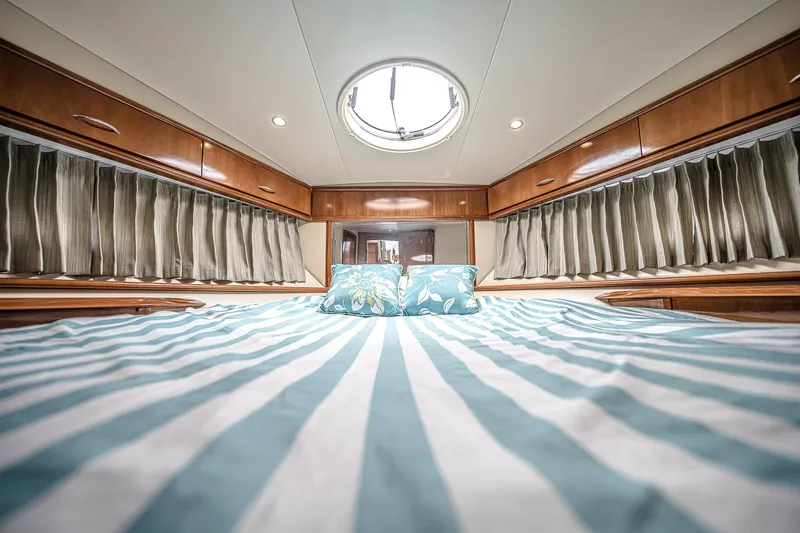 Fiesta Bayb Yacht Photos Pics Luxurious interior of 2003 Carver 444 Cockpit Motor Yacht with striped bedding and wood accents.