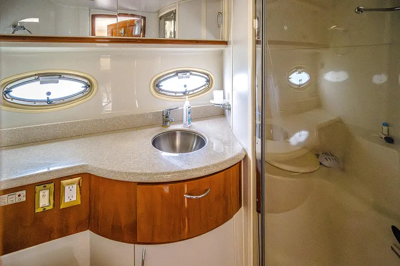 Fiesta Bayb Yacht Photos Pics Luxurious bathroom in 2003 Carver 444 Cockpit Motor Yacht with modern fixtures and porthole windows.