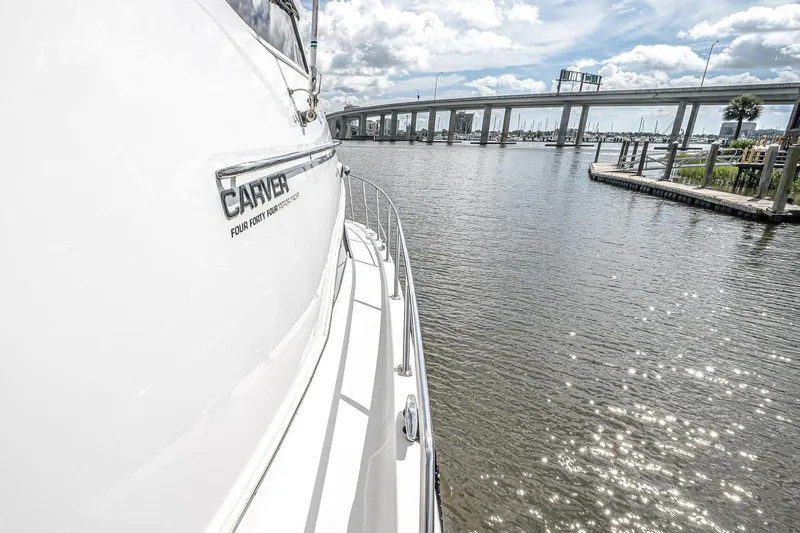 Fiesta Bayb Yacht Photos Pics 2003 Carver 444 Cockpit Motor Yacht docked near a bridge on a sunny day.