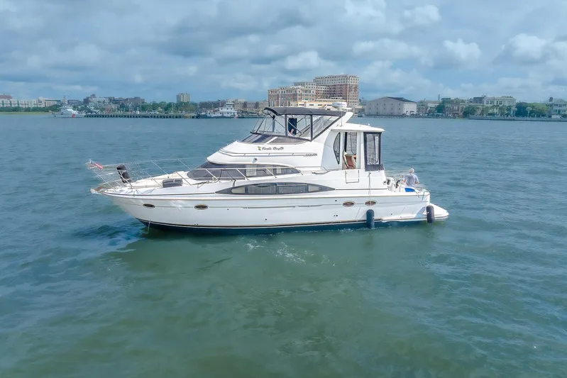Fiesta Bayb Yacht Photos Pics 2003 Carver 444 Cockpit Motor Yacht cruising on calm waters near a cityscape.