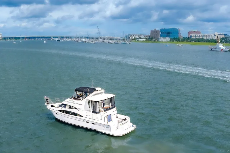 Fiesta Bayb Yacht Photos Pics 2003 Carver 444 Cockpit Motor Yacht cruising on a scenic waterway under cloudy skies.