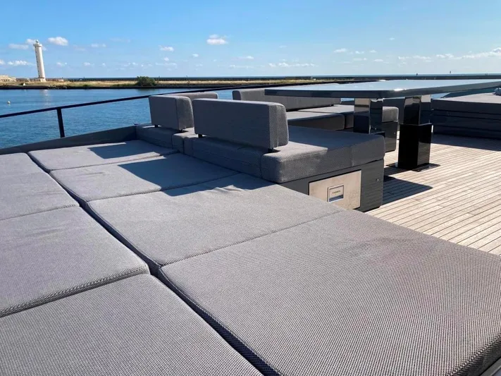  Yacht Photos Pics Luxurious AB Yachts 100 deck with modern seating, ocean view, and lighthouse in the background.