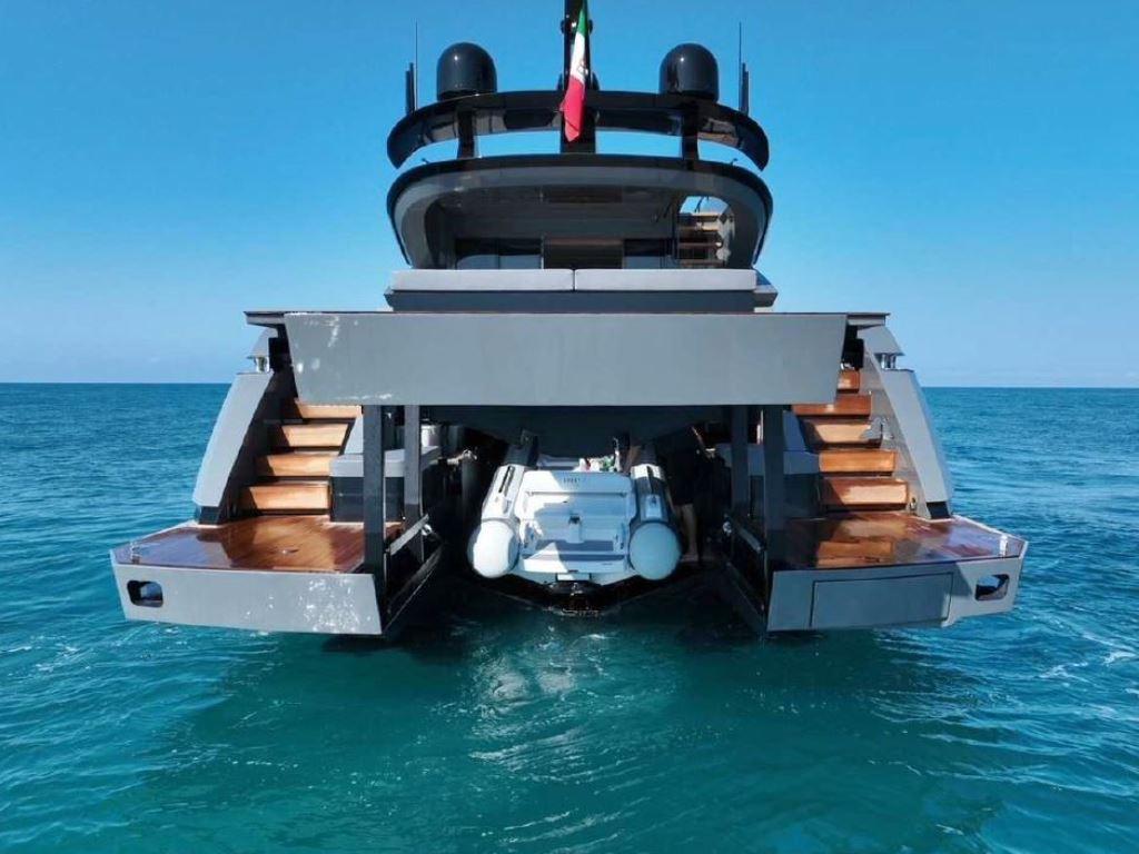Luxury AB Yachts 100, 2022 model, with tender, on clear blue water.