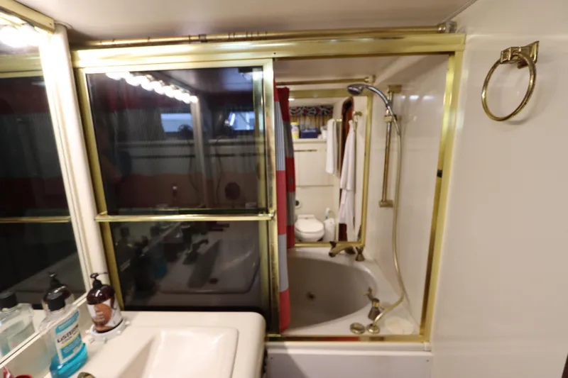  Yacht Photos Pics Bathroom in a 1991 Viking Motor Yacht with gold fixtures and a shower-tub combo.