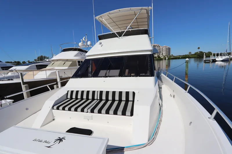  Yacht Photos Pics 1991 Viking Motor Yacht with striped seating, docked in a marina under clear blue skies.