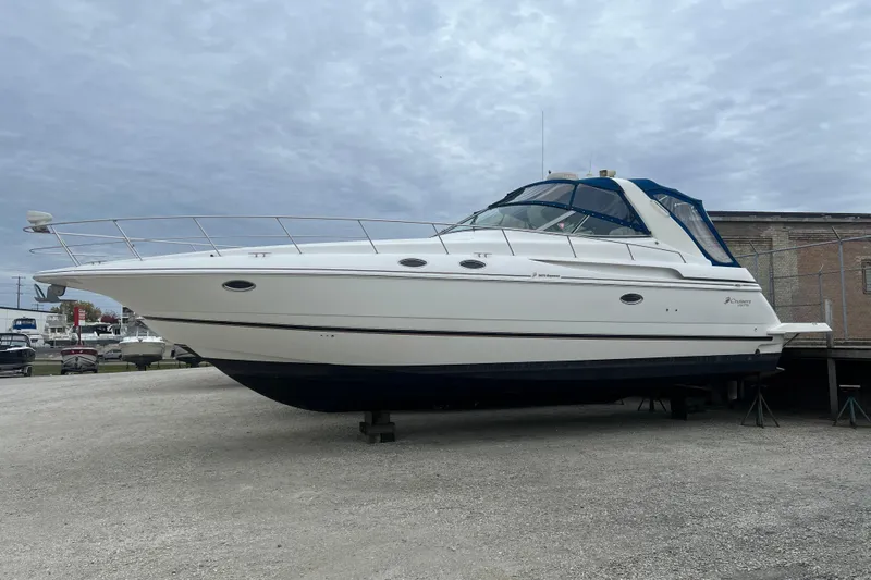 Getaway Yacht Photos Pics 2000 Cruisers Yachts 3870 Express boat on dry dock under cloudy sky.