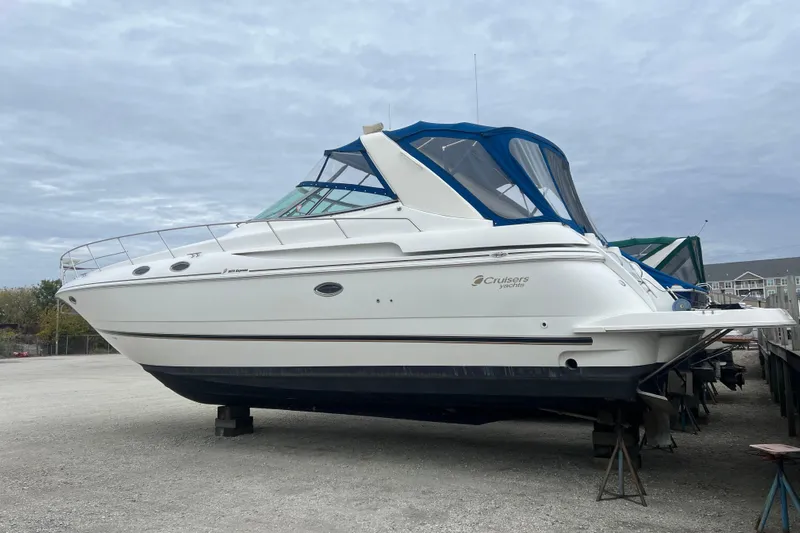 Getaway Yacht Photos Pics 2000 Cruisers Yachts 3870 Express on dry dock, featuring sleek white design and blue canopy.