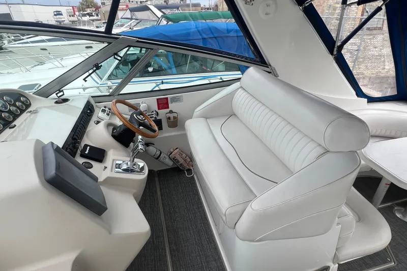 Getaway Yacht Photos Pics 2000 Cruisers Yachts 3870 Express helm with white seating and wooden steering wheel.