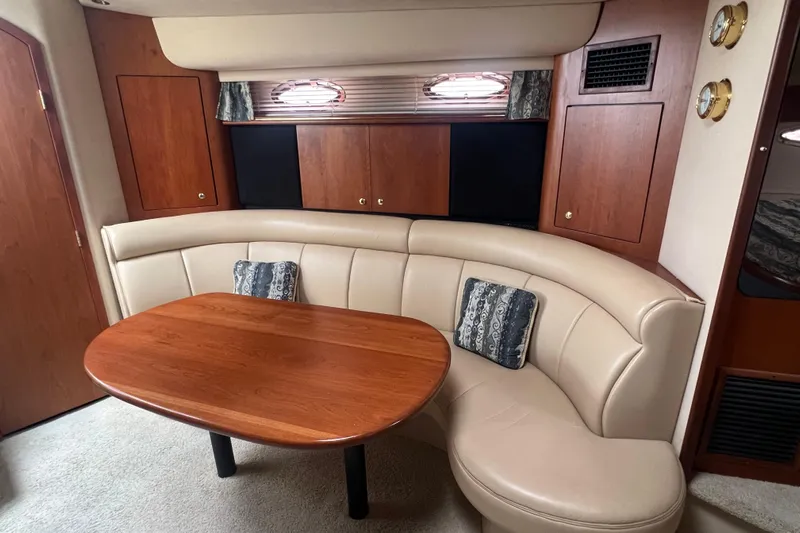 Getaway Yacht Photos Pics 2000 Cruisers Yachts 3870 Express interior with curved seating and wooden table.