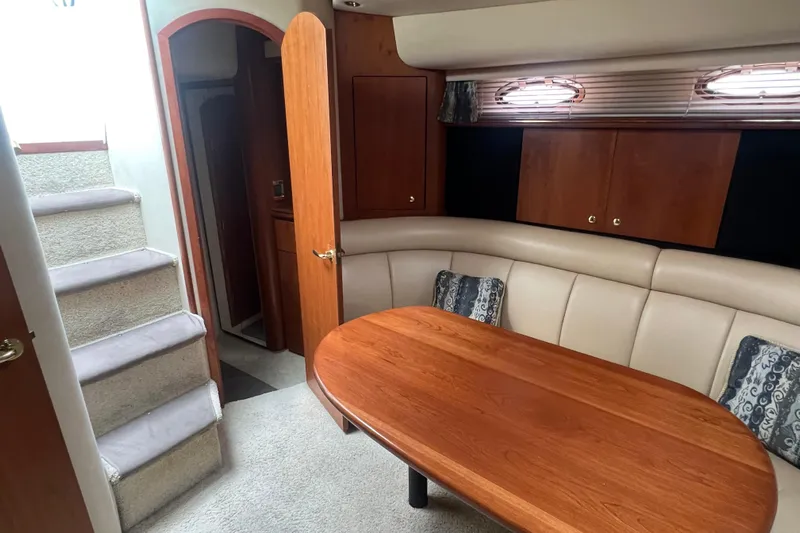 Getaway Yacht Photos Pics Interior of 2000 Cruisers Yachts 3870 Express with wooden table and cushioned seating.