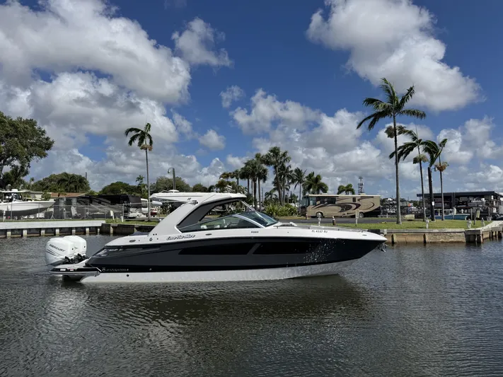 Love You More Yacht Photos Pics 2019 Four Winns H350 boat on a sunny day with palm trees in the background.