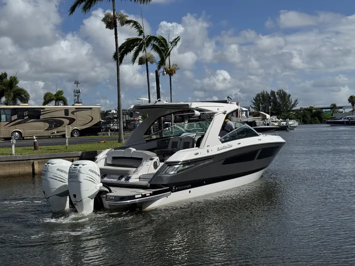 Love You More Yacht Photos Pics 2019 Four Winns H350 boat cruising on a sunny day with palm trees in the background.