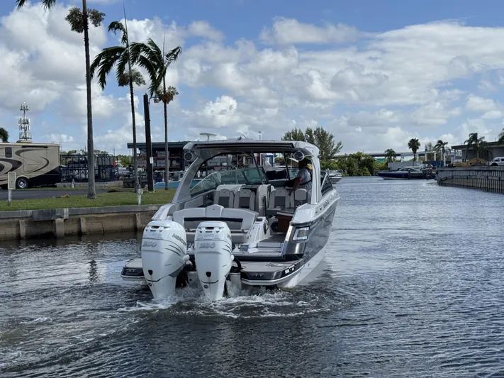 Love You More Yacht Photos Pics 2019 Four Winns H350 boat cruising on a sunny day with palm trees in the background.