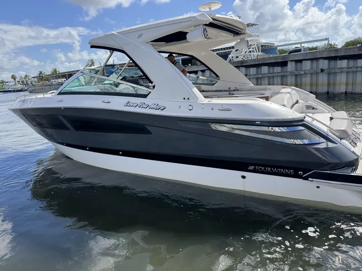 Love You More Yacht Photos Pics 2019 Four Winns H350 boat on water, sleek design, sunny day, marina background.