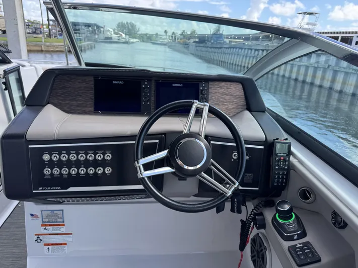 Love You More Yacht Photos Pics 2019 Four Winns 350H boat helm with steering wheel, controls, and navigation screens.