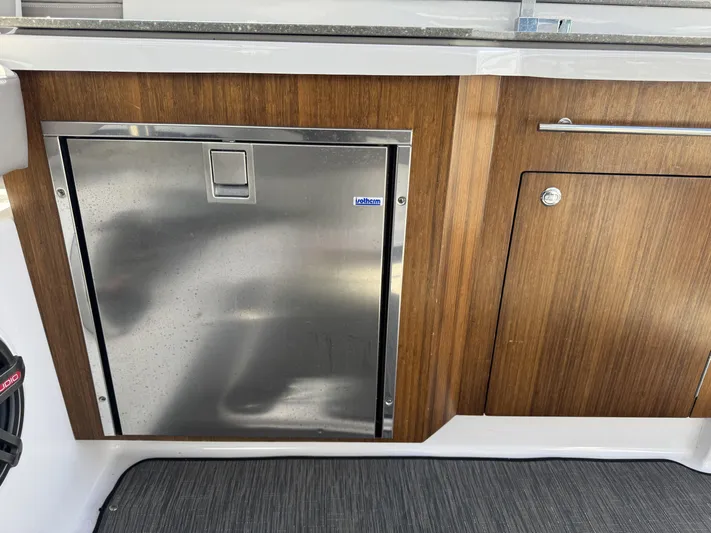 Love You More Yacht Photos Pics 2019 Four Winns 350H boat interior with stainless steel fridge and wooden cabinetry.