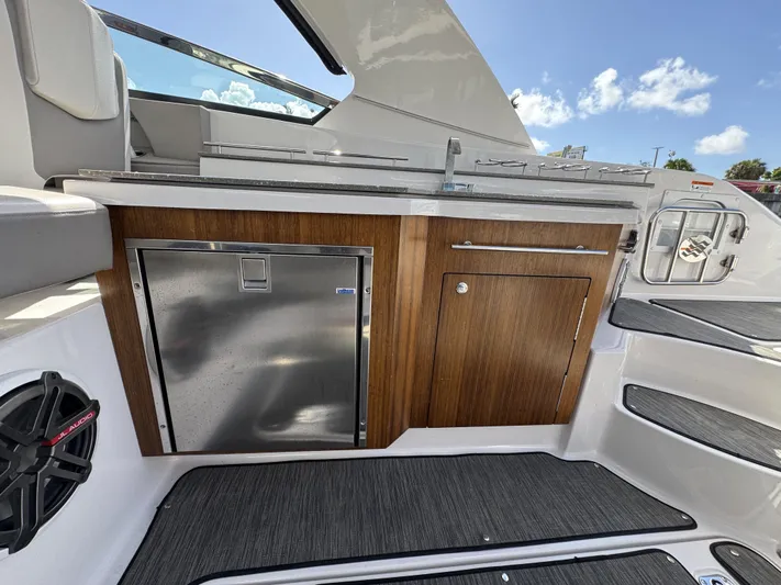 Love You More Yacht Photos Pics 2019 Four Winns 350H boat interior with wood cabinetry and stainless steel fridge.