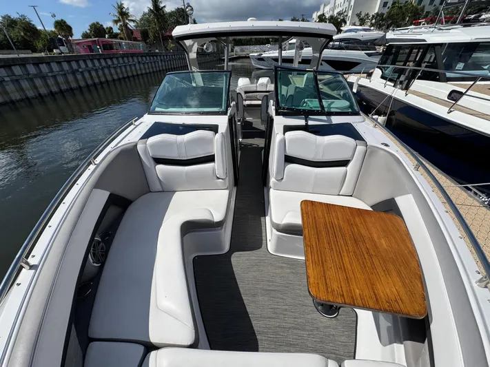 Love You More Yacht Photos Pics 2019 Four Winns 350H boat interior with white seating and wooden table, docked by the water.