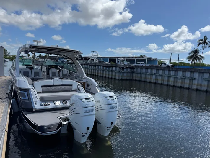 Love You More Yacht Photos Pics 2019 Four Winns 350H boat docked, featuring dual outboard engines under a clear blue sky.