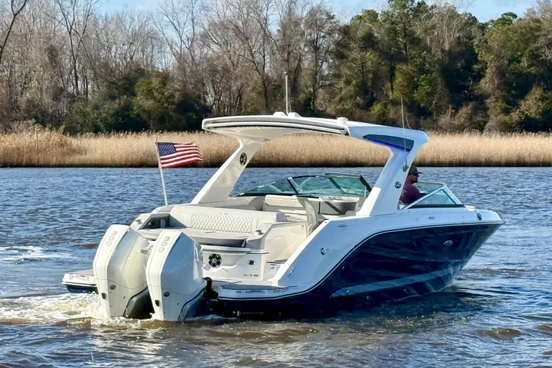  Yacht Photos Pics 2021 Sea Ray SLX 310 Outboard cruising on a scenic river with American flag.