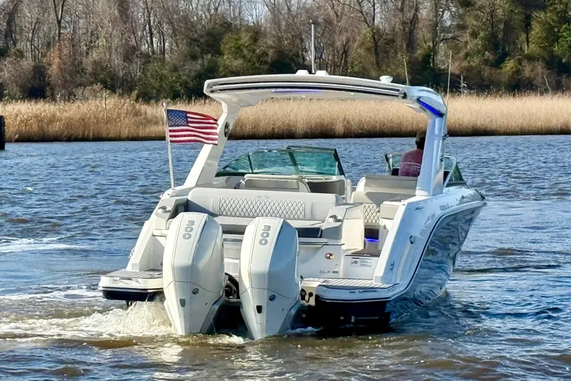  Yacht Photos Pics 2021 Sea Ray SLX 310 Outboard boat cruising on a river with American flag.