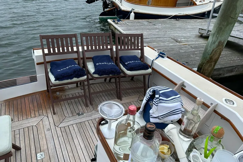 Renegade Yacht Photos Pics 1994 Little Harbor Express boat with wooden deck, chairs, and drinks near a dock.