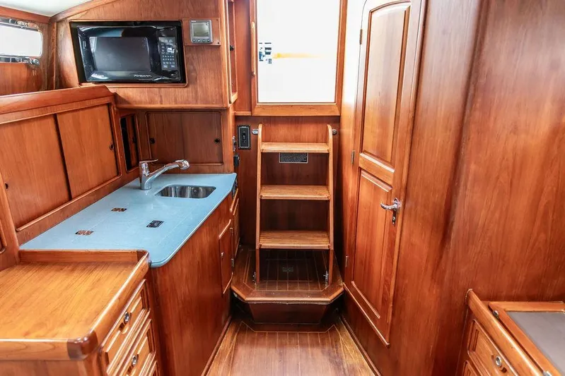 Renegade Yacht Photos Pics 1994 Little Harbor Express yacht interior with wooden cabinetry and compact kitchen area.