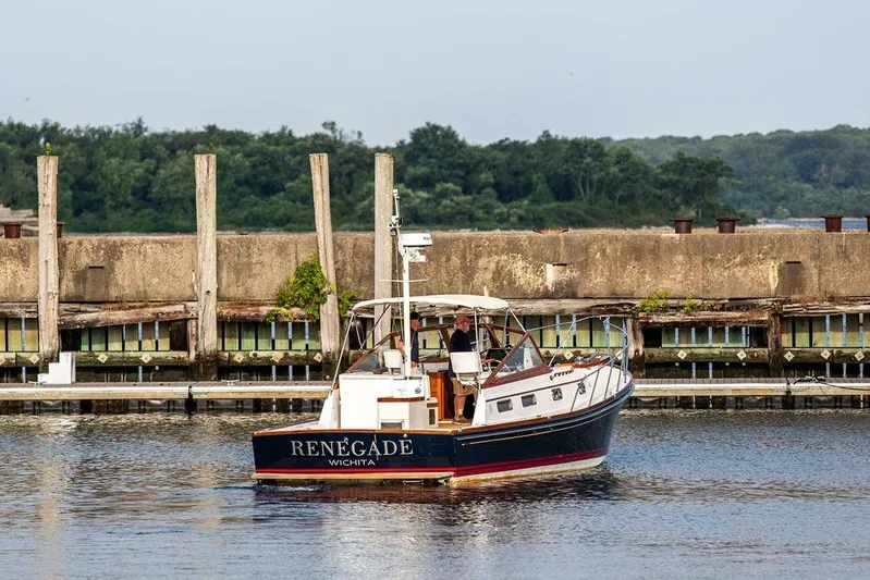 Renegade Yacht Photos Pics 1994 Little Harbor Express boat named "Renegade" on calm water near a dock.