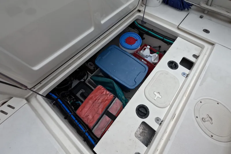 32 Boston Whaler Outrage 2013 Yacht Photos Pics Storage compartment of a 2013 Boston Whaler 320 Outrage, containing various boating supplies.