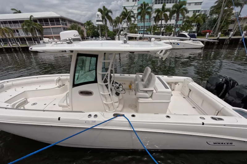32 Boston Whaler Outrage 2013 Yacht Photos Pics 2013 Boston Whaler 320 Outrage boat docked by waterfront buildings.