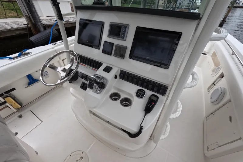 32 Boston Whaler Outrage 2013 Yacht Photos Pics 2013 Boston Whaler 320 Outrage helm with steering wheel, controls, and navigation screens.