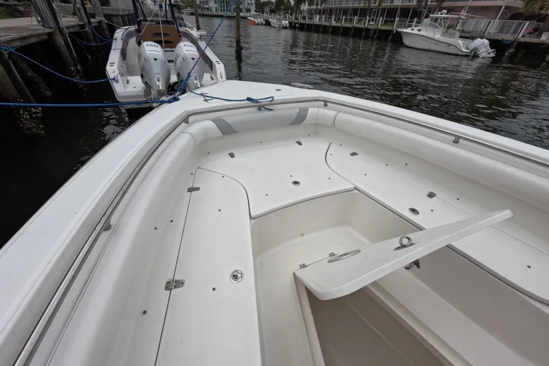 32 Boston Whaler Outrage 2013 Yacht Photos Pics 2013 Boston Whaler 320 Outrage boat interior with open storage compartment, docked by the water.