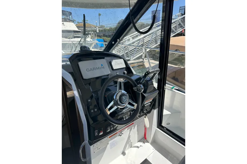 Destination Unknown II Yacht Photos Pics 2021 Jeanneau NC895 helm with Garmin navigation system and steering wheel.