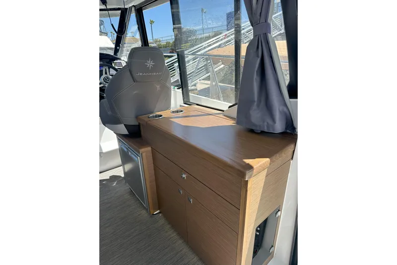 Destination Unknown II Yacht Photos Pics 2021 Jeanneau NC895 interior with wooden cabinetry and captain's chair, showcasing modern design.