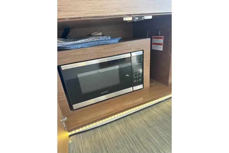 Destination Unknown II Yacht Photos Pics Microwave in 2021 Jeanneau NC895 boat interior, wooden cabinetry, modern design.