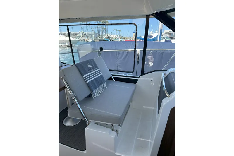 Destination Unknown II Yacht Photos Pics Interior of 2021 Jeanneau NC895 boat with cushioned seating and marina view.