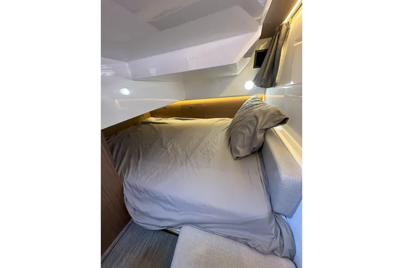 Destination Unknown II Yacht Photos Pics Cozy cabin interior of 2021 Jeanneau NC895 with comfortable bedding and ambient lighting.