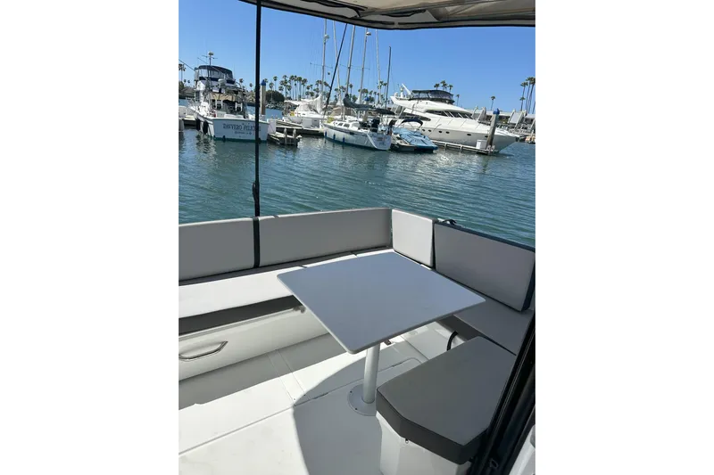 Destination Unknown II Yacht Photos Pics 2021 Jeanneau NC895 boat interior with seating and table, docked at marina.