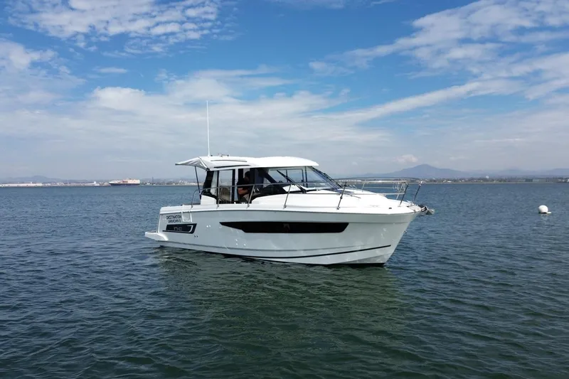 Destination Unknown II Yacht Photos Pics 2021 Jeanneau NC895 boat on calm water under a blue sky.