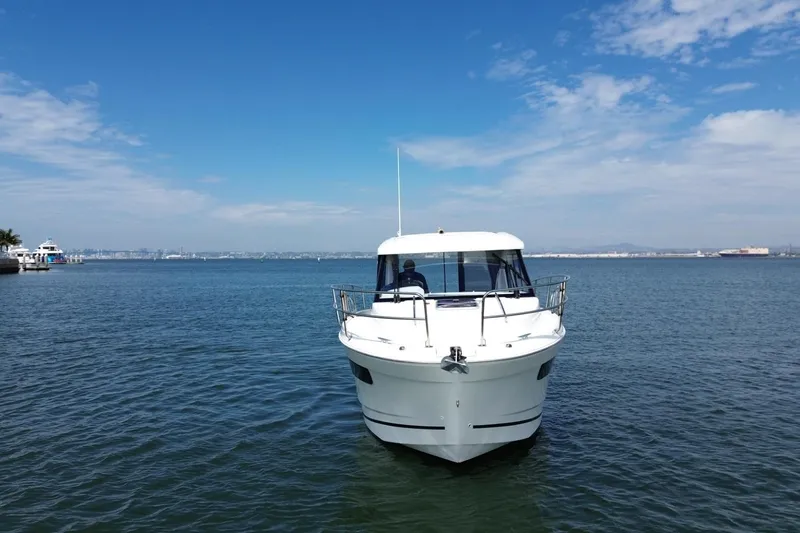 Destination Unknown II Yacht Photos Pics 2021 Jeanneau NC895 boat on calm water under a clear blue sky.