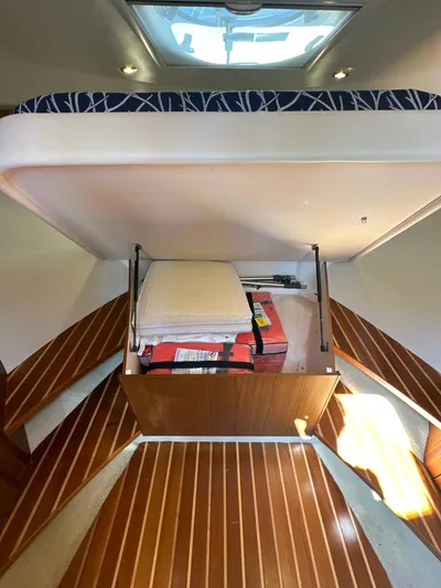  Yacht Photos Pics 2014 Tiara Yachts 3100 Coronet interior with under-bed storage and wooden flooring.