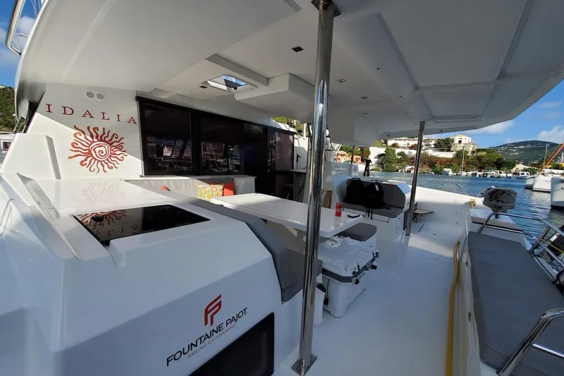 Idalia Yacht Photos Pics 2020 Fountaine Pajot Saona 47 Maestro catamaran, spacious deck with seating, docked in marina.