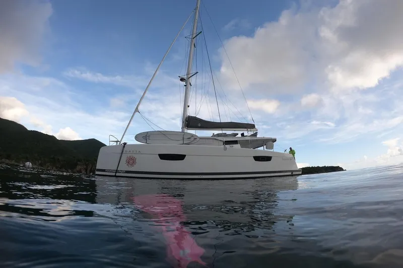 Idalia Yacht Photos Pics 2020 Fountaine Pajot Saona 47 Maestro catamaran sailing on calm waters under a clear sky.