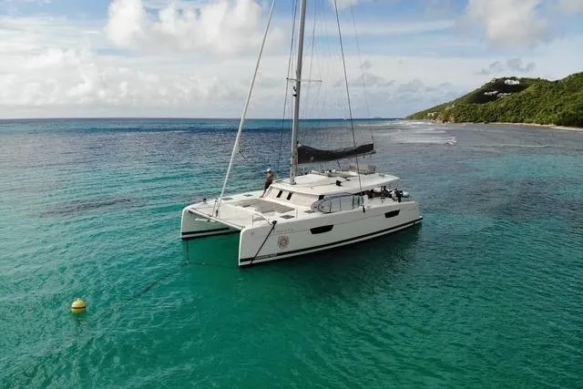 Idalia Yacht Photos Pics 2020 Fountaine Pajot Saona 47 Maestro catamaran sailing in clear turquoise waters.