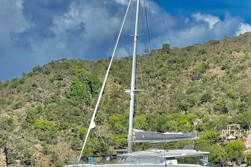 Idalia Yacht Photos Pics 2020 Fountaine Pajot Saona 47 Maestro catamaran docked near lush hillside.