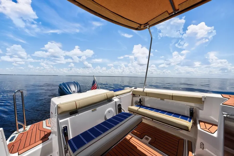 Yacht Photos Pics 2024 Ranger Tugs R-27 boat interior with ocean view, featuring seating and canopy.