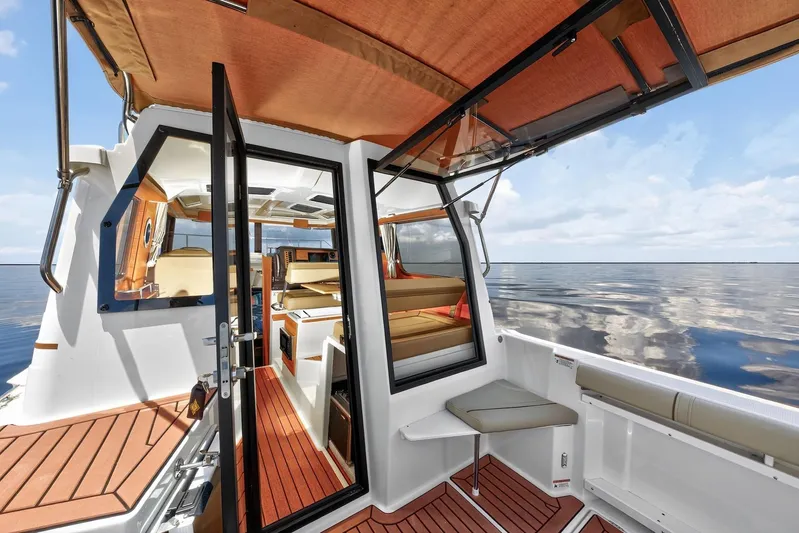  Yacht Photos Pics 2024 Ranger Tugs R-27 interior with open cabin, wood accents, and ocean view.