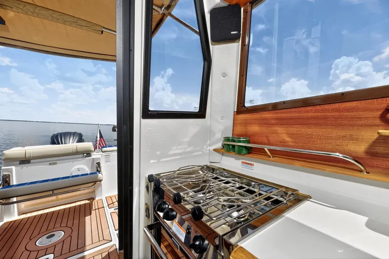  Yacht Photos Pics 2024 Ranger Tugs R-27 interior with stove, wooden accents, and ocean view.