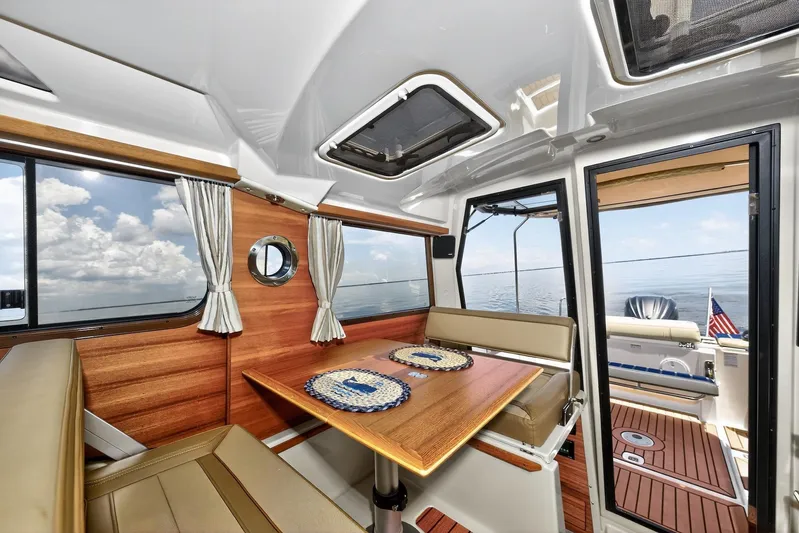  Yacht Photos Pics Interior of 2024 Ranger Tugs R-27 boat with wooden dining area and ocean view.