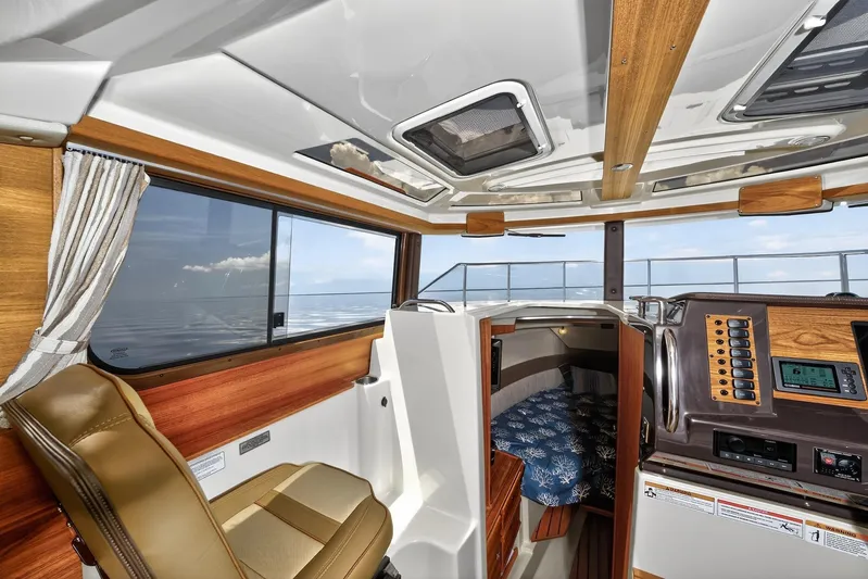  Yacht Photos Pics 2024 Ranger Tugs R-27 interior with helm, seating, and cabin view.